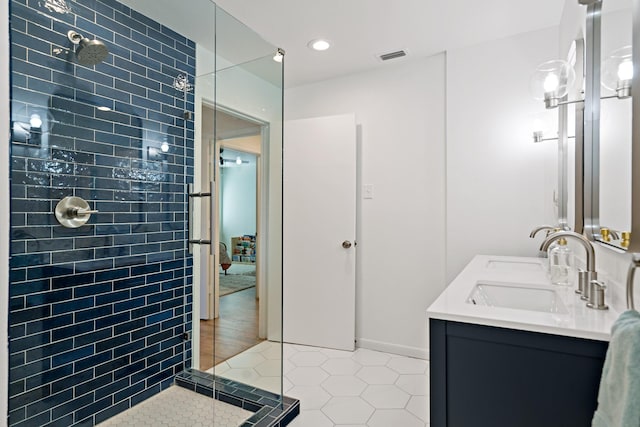 bathroom featuring vanity, tile patterned floors, and tiled shower