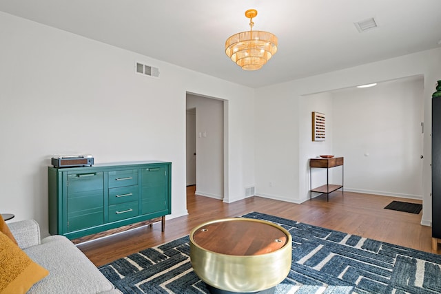 living area with dark hardwood / wood-style floors and an inviting chandelier