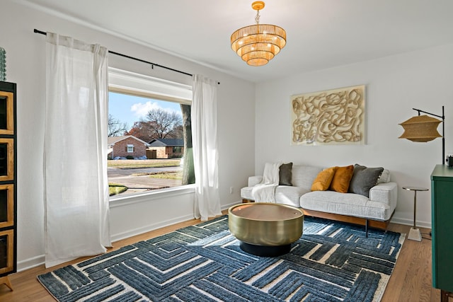 sitting room featuring hardwood / wood-style floors and an inviting chandelier