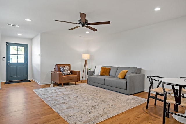 living room featuring light hardwood / wood-style flooring and ceiling fan