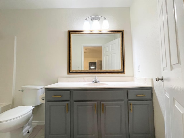 bathroom featuring vanity, a bathtub, tile patterned floors, and toilet