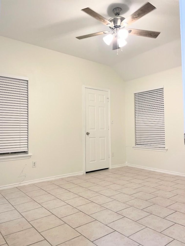 tiled spare room featuring ceiling fan and vaulted ceiling