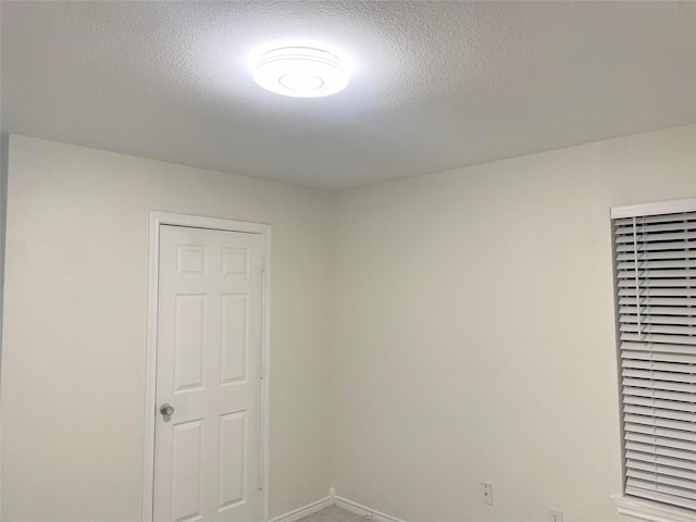 unfurnished room with a textured ceiling