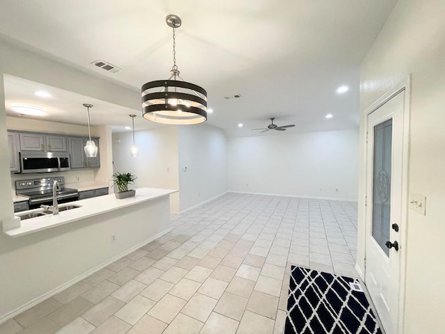 kitchen with sink, gray cabinets, ceiling fan, appliances with stainless steel finishes, and light tile patterned flooring