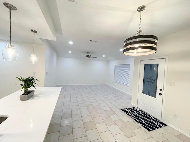 interior space featuring ceiling fan with notable chandelier