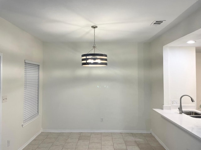 unfurnished dining area with sink and a chandelier