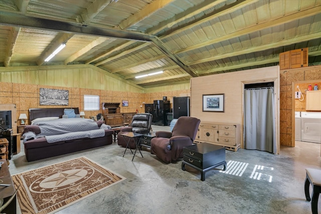 bedroom with concrete flooring, vaulted ceiling, and washing machine and clothes dryer