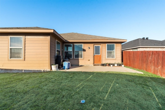 back of house with a yard and a patio