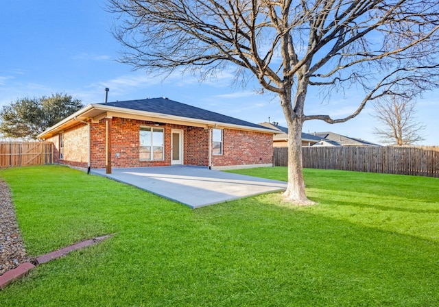 rear view of property with a yard and a patio area