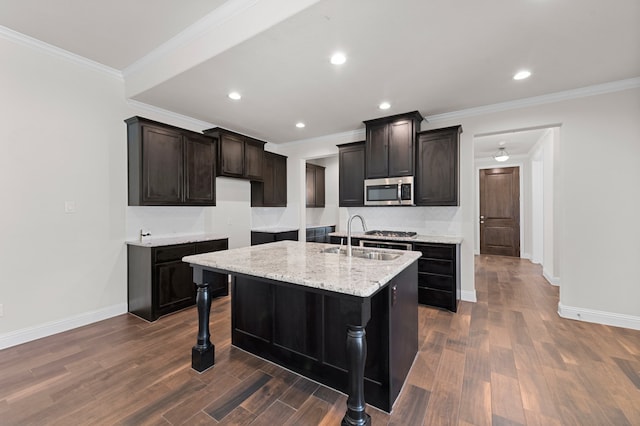 kitchen featuring sink, crown molding, an island with sink, a kitchen bar, and dark hardwood / wood-style flooring