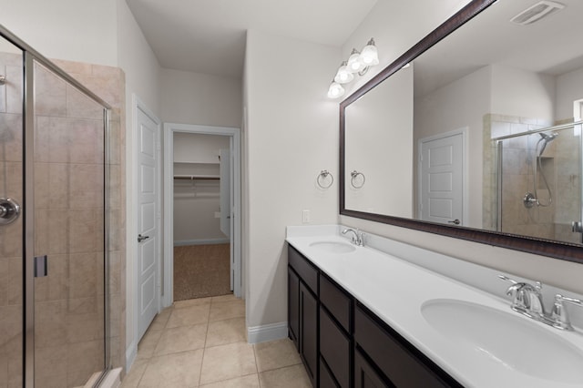 bathroom featuring a shower with door, vanity, and tile patterned floors