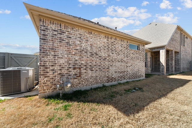 view of side of property featuring central AC and a lawn