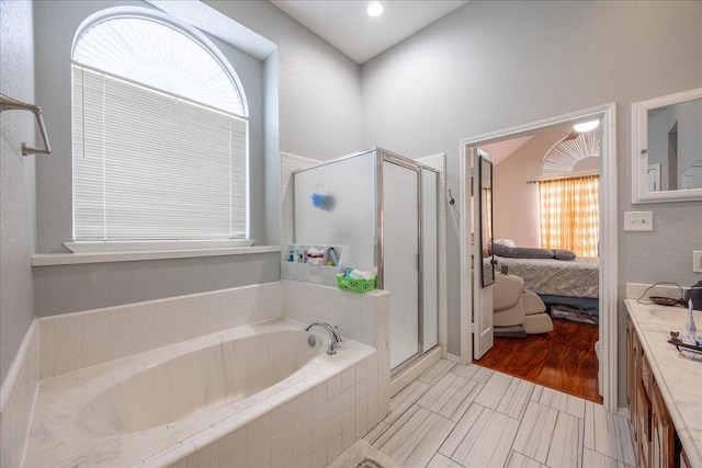 bathroom featuring vanity, independent shower and bath, and a wealth of natural light