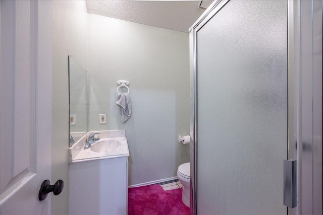 bathroom with vanity, a textured ceiling, and toilet