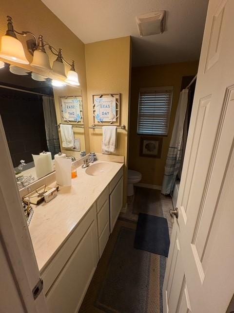 bathroom with vanity, toilet, and curtained shower