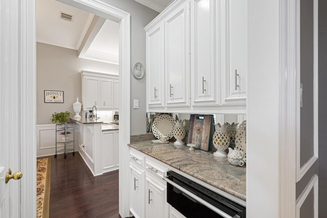 bar featuring white cabinetry, light stone counters, and crown molding