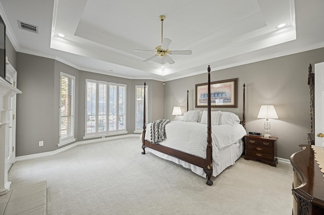 carpeted bedroom with ceiling fan, ornamental molding, and a raised ceiling