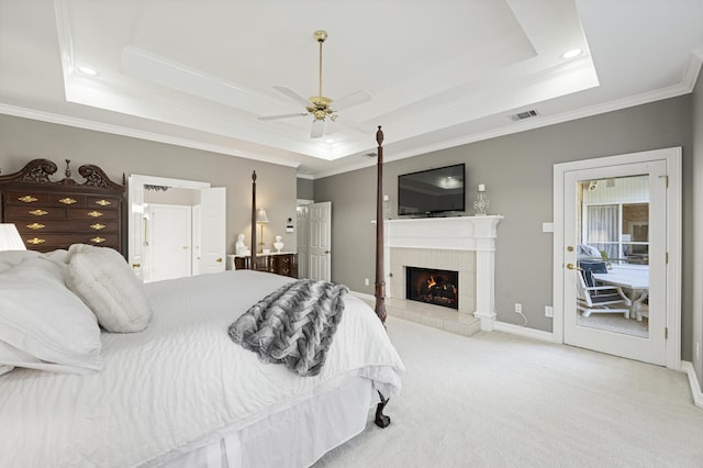 bedroom with ceiling fan, a raised ceiling, and light colored carpet