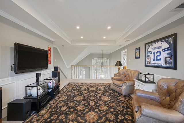 living room featuring a raised ceiling, crown molding, and a chandelier