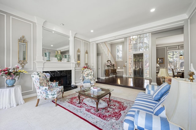 living room featuring crown molding, light colored carpet, and a tile fireplace