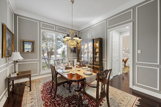 dining area with an inviting chandelier, ornamental molding, and dark wood-type flooring