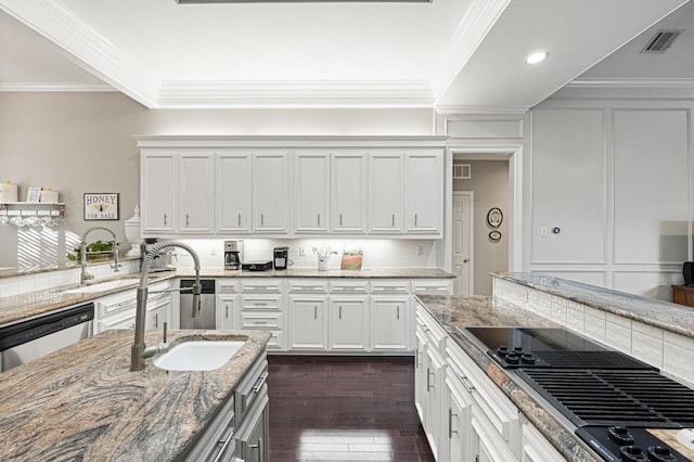 kitchen with sink, backsplash, light stone counters, white cabinets, and stainless steel dishwasher