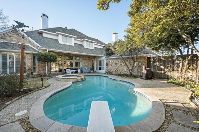 view of pool featuring an in ground hot tub, a diving board, and a patio