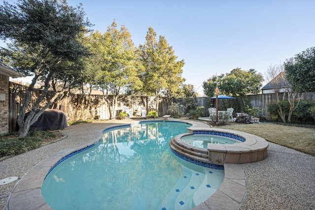 view of swimming pool featuring an in ground hot tub and a diving board