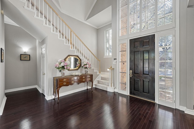 entrance foyer featuring crown molding, a towering ceiling, and wood-type flooring