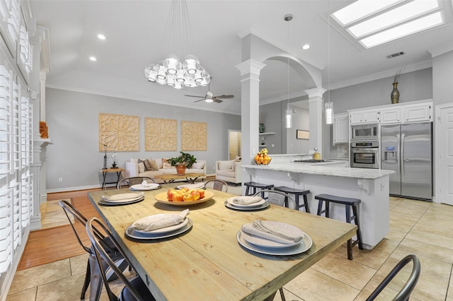 dining room with ceiling fan, ornamental molding, decorative columns, and light tile patterned floors