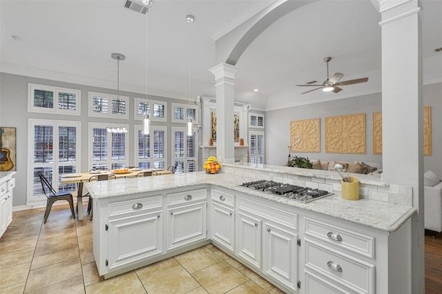 kitchen with stainless steel gas stovetop, white cabinetry, pendant lighting, and kitchen peninsula