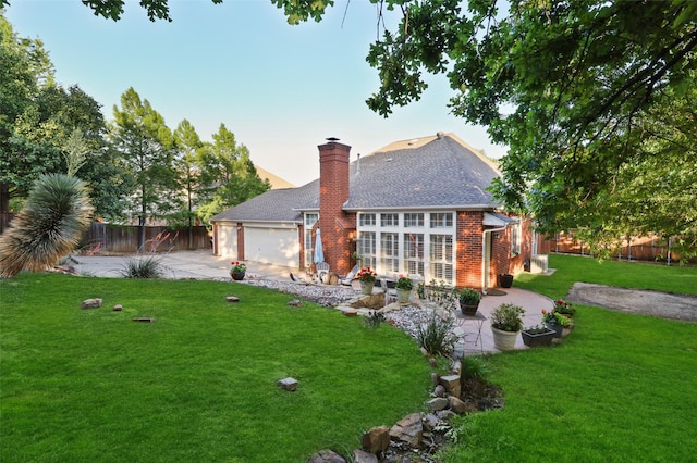 back house at dusk featuring a yard, a garage, and a patio