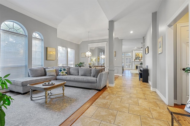 living room with crown molding, plenty of natural light, a chandelier, and light tile patterned flooring