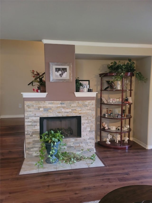 living room with hardwood / wood-style floors, crown molding, and a fireplace