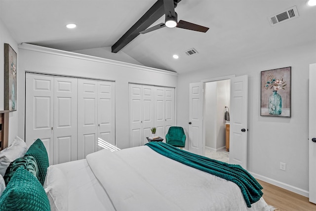 bedroom featuring light wood-type flooring, multiple closets, lofted ceiling with beams, and ceiling fan