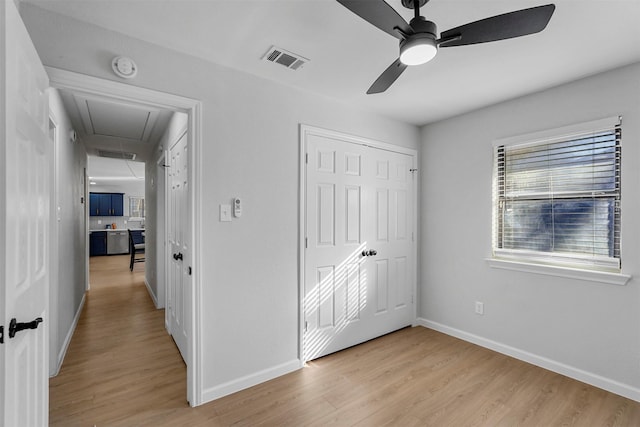 unfurnished bedroom featuring light hardwood / wood-style flooring, ceiling fan, and a closet