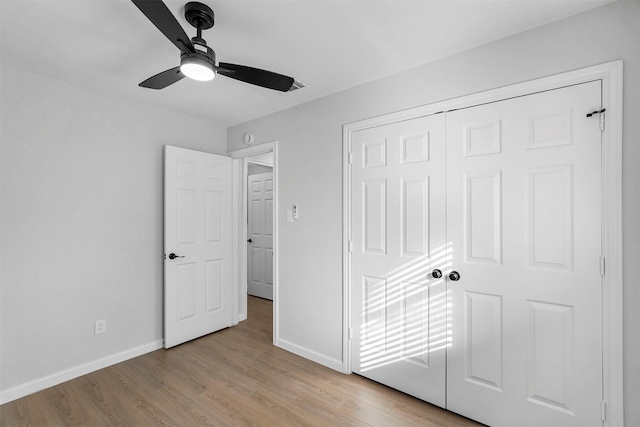 unfurnished bedroom with ceiling fan, light hardwood / wood-style floors, and a closet