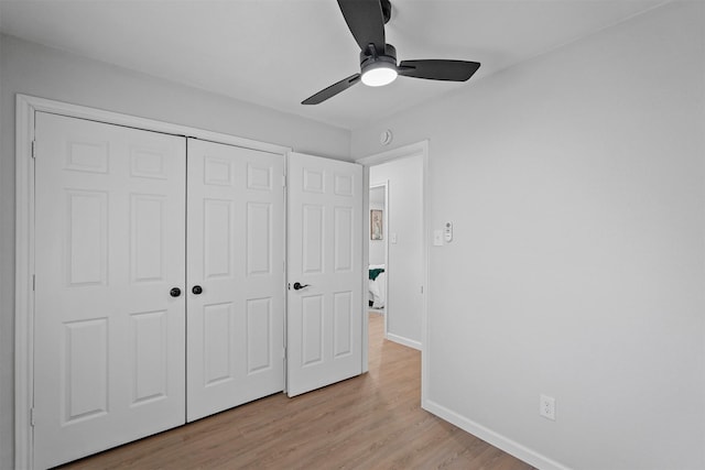 unfurnished bedroom with light wood-type flooring, a closet, and ceiling fan