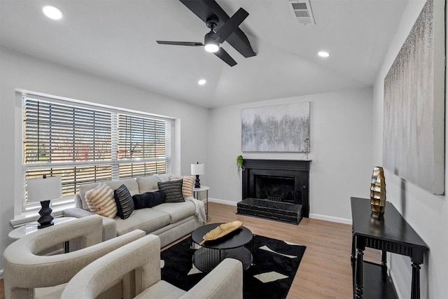 living room with ceiling fan, lofted ceiling, and light hardwood / wood-style floors