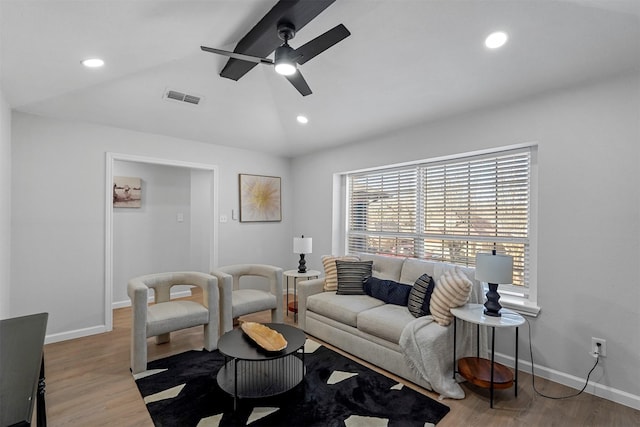 living room with light hardwood / wood-style floors, vaulted ceiling, and ceiling fan