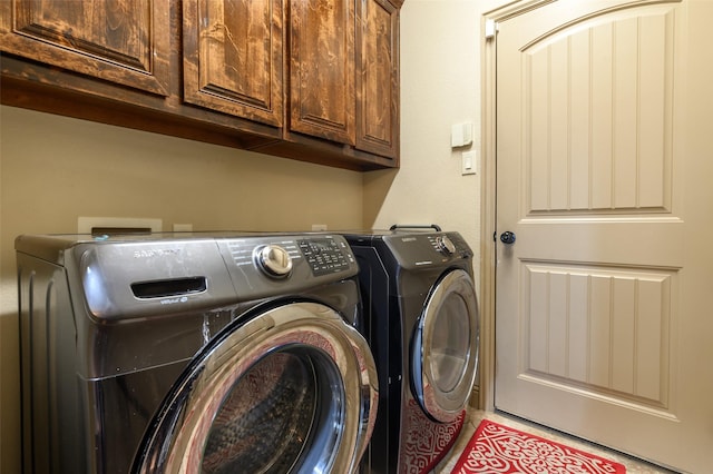 clothes washing area with cabinets, washing machine and clothes dryer, and light tile patterned flooring