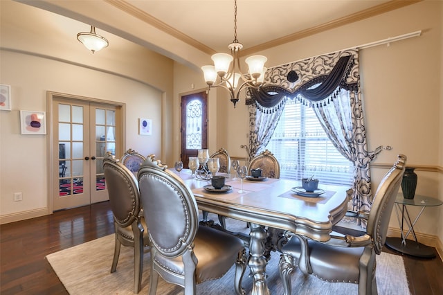 dining area featuring crown molding, an inviting chandelier, dark hardwood / wood-style flooring, and french doors