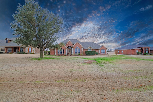 ranch-style home featuring a lawn