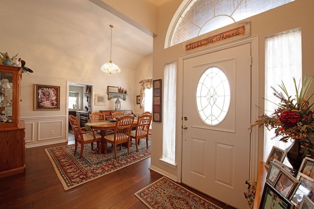 entrance foyer with dark hardwood / wood-style flooring and high vaulted ceiling