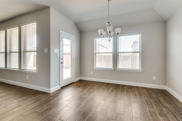 unfurnished dining area with hardwood / wood-style flooring, vaulted ceiling, and a notable chandelier