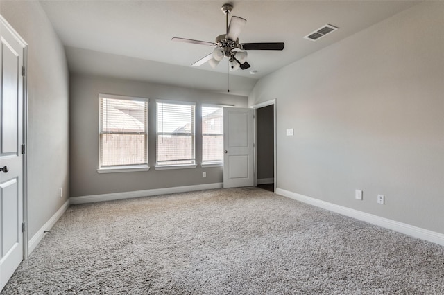 spare room with ceiling fan, vaulted ceiling, and carpet