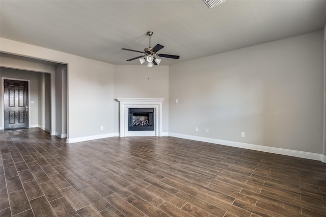 unfurnished living room featuring dark wood-type flooring and ceiling fan