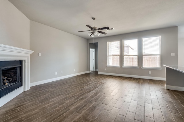 unfurnished living room featuring ceiling fan and dark hardwood / wood-style flooring