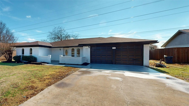 ranch-style home with a garage and a front lawn