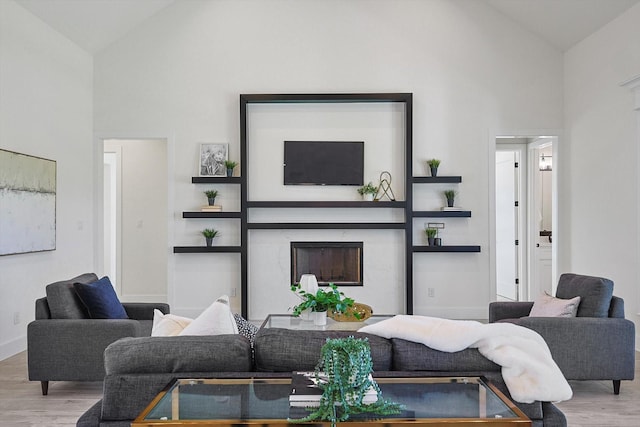 living room with hardwood / wood-style floors and high vaulted ceiling